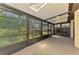 Enclosed lanai with tile flooring, ceiling fan, and expansive windows offering scenic views at 5641 Mashie Cir, North Port, FL 34287