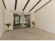 Bright living room with exposed beams providing access to a screened in porch at 5641 Mashie Cir, North Port, FL 34287