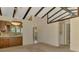 Spacious room with exposed beams, providing access to the kitchen and laundry areas at 5641 Mashie Cir, North Port, FL 34287