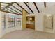 Open-concept living room featuring exposed beams, bay window and kitchen view at 5641 Mashie Cir, North Port, FL 34287