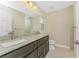 Bathroom featuring double sinks, granite countertops, dark wood cabinets, and tile flooring at 6274 Skyview Dr, North Port, FL 34291