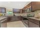 Modern kitchen boasts granite countertops, stainless steel appliances, tile backsplash, and dark wood cabinetry at 6274 Skyview Dr, North Port, FL 34291