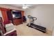 A spacious bedroom with a treadmill, tv, dresser, and a ceiling fan at 7148 N Blue Sage, Punta Gorda, FL 33955