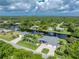 Stunning aerial view of a waterfront home with lush landscaping and a private dock at 1025 Cheshire St, Port Charlotte, FL 33953