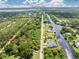 Aerial view of a waterfront property, showcasing the home, expansive yard, and canal access at 1025 Cheshire St, Port Charlotte, FL 33953