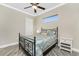 This bedroom features a ceiling fan, transom window, and neutral colored walls at 1025 Cheshire St, Port Charlotte, FL 33953