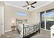 This cozy bedroom features a ceiling fan, transom window, and sliding doors to the pool area at 1025 Cheshire St, Port Charlotte, FL 33953