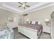 An ample main bedroom features a tray ceiling, ceiling fan and wooden-look flooring at 1025 Cheshire St, Port Charlotte, FL 33953
