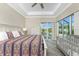 This well-lit main bedroom features a tray ceiling, ceiling fan and sliding glass door at 1025 Cheshire St, Port Charlotte, FL 33953