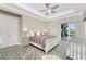 A well-lit main bedroom features a tray ceiling, ceiling fan and sliding glass door at 1025 Cheshire St, Port Charlotte, FL 33953