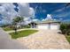 A stunning residence featuring a beautiful brick driveway and a large, three-car garage, surrounded by green lawns at 1025 Cheshire St, Port Charlotte, FL 33953