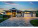 Beautifully landscaped home features a paver driveway and manicured lawn at 1025 Cheshire St, Port Charlotte, FL 33953