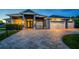 Exterior view of a modern home with a well-manicured lawn and a paver driveway at 1025 Cheshire St, Port Charlotte, FL 33953