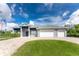A contemporary home featuring a three-car garage, paver driveway, and manicured front lawn at 1025 Cheshire St, Port Charlotte, FL 33953