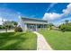 Charming gray home with a quaint front porch, landscaped yard, and a welcoming stone walkway to the entrance at 1025 Cheshire St, Port Charlotte, FL 33953