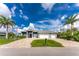 Inviting home with a well-manicured lawn and a spacious three-car garage, complemented by tropical palm trees at 1025 Cheshire St, Port Charlotte, FL 33953