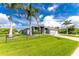 Beautiful home with palm trees, a green lawn, and a charming fence enhancing curb appeal at 1025 Cheshire St, Port Charlotte, FL 33953