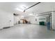 Spacious three-car garage with epoxy floors, overhead storage, and ample lighting at 1025 Cheshire St, Port Charlotte, FL 33953