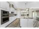 A modern kitchen featuring white cabinets, granite counters, stainless appliances, and wood flooring at 1025 Cheshire St, Port Charlotte, FL 33953