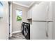 Well-lit laundry area with a washer, dryer, white cabinets and a granite countertop at 1025 Cheshire St, Port Charlotte, FL 33953