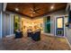 Covered patio with a wood ceiling, ceiling fan, and outdoor seating area with sliding doors to the main house at 1025 Cheshire St, Port Charlotte, FL 33953