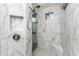 The glass enclosed shower features marble tile, a built-in niche, and a rain shower head at 1025 Cheshire St, Port Charlotte, FL 33953