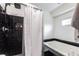 Bathroom featuring black tiled shower and tub with white walls and a sleek, modern design at 10289 60Th N Cir, Pinellas Park, FL 33782