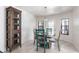 Dining area showcasing a round wooden table, natural lighting, and tiled floors at 10289 60Th N Cir, Pinellas Park, FL 33782