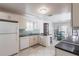 Open-concept kitchen featuring white cabinetry, granite countertops, and a breakfast bar at 10289 60Th N Cir, Pinellas Park, FL 33782