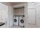 Convenient laundry room with washer, dryer, shelving and neutral tile flooring at 10289 60Th N Cir, Pinellas Park, FL 33782