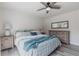 Bright main bedroom features a ceiling fan, a wooden dresser with a mirror, and a cozy bed with blue accents at 10289 60Th N Cir, Pinellas Park, FL 33782