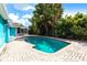 Private in-ground pool with brick paver surround and lush tropical landscaping at 10289 60Th N Cir, Pinellas Park, FL 33782