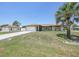 Charming single-story home featuring an attached garage, concrete drive and mature palm trees at 1039 Marlene St, Port Charlotte, FL 33952