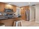 Kitchen with wooden cabinets, stainless steel refrigerator, and breakfast bar with seating at 1039 Marlene St, Port Charlotte, FL 33952