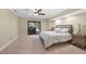 Main bedroom with plush carpeting, fan, access to the screened in lanai, and side tables at 1039 Marlene St, Port Charlotte, FL 33952