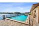 Pool overlooking the water with deck chairs and lounge area under archways at 1217 Aqui Esta Dr # 5, Punta Gorda, FL 33950
