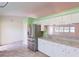 View of kitchen shows stainless refrigerator and view to other room at 1351 Washington Dr, Englewood, FL 34224