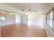 Spacious living room with wood-look flooring, a ceiling fan, and large windows at 1351 Washington Dr, Englewood, FL 34224
