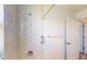 Tiled shower with glass door and adjustable shower head, in a well-lit bathroom at 1351 Washington Dr, Englewood, FL 34224