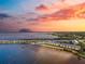 Sunset view of the waterfront condos with pier, beach, and pool, creating the perfect coastal retreat at 14459 River Beach Dr # 112, Port Charlotte, FL 33953