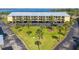 Aerial view of the building shows a parking area, courtyard with palm trees, and building exterior at 14459 River Beach Dr # 112, Port Charlotte, FL 33953