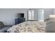 Bright bedroom features a large bed, blue dresser with a TV, and a peek into the en-suite bathroom at 14459 River Beach Dr # 112, Port Charlotte, FL 33953