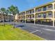 View of the condos on stilts with ground level parking and palm trees in the landscaping at 14459 River Beach Dr # 112, Port Charlotte, FL 33953