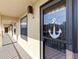 Exterior of condo unit door with anchor decor and a view down the outdoor hallway at 14459 River Beach Dr # 112, Port Charlotte, FL 33953