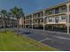 View of the condos on stilts with ground level parking and palm trees in the landscaping at 14459 River Beach Dr # 112, Port Charlotte, FL 33953