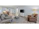 Spacious living room offering great natural light, wood-style floors, and modern furnishings for comfortable living at 14459 River Beach Dr # 112, Port Charlotte, FL 33953