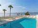 Inviting community pool area with lounge chairs, lush landscaping, and stunning water views at 14459 River Beach Dr # 112, Port Charlotte, FL 33953