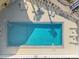 Aerial view of a large rectangular pool, surrounded by lounge chairs, and lush landscaping at 14459 River Beach Dr # 112, Port Charlotte, FL 33953