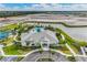 Aerial view of a modern community clubhouse with pool, lake, and construction in background at 15968 Crofton Springs Way, Port Charlotte, FL 33953