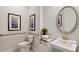 Well-lit bathroom featuring a pedestal sink, oval mirror and decorative artwork at 15968 Crofton Springs Way, Port Charlotte, FL 33953